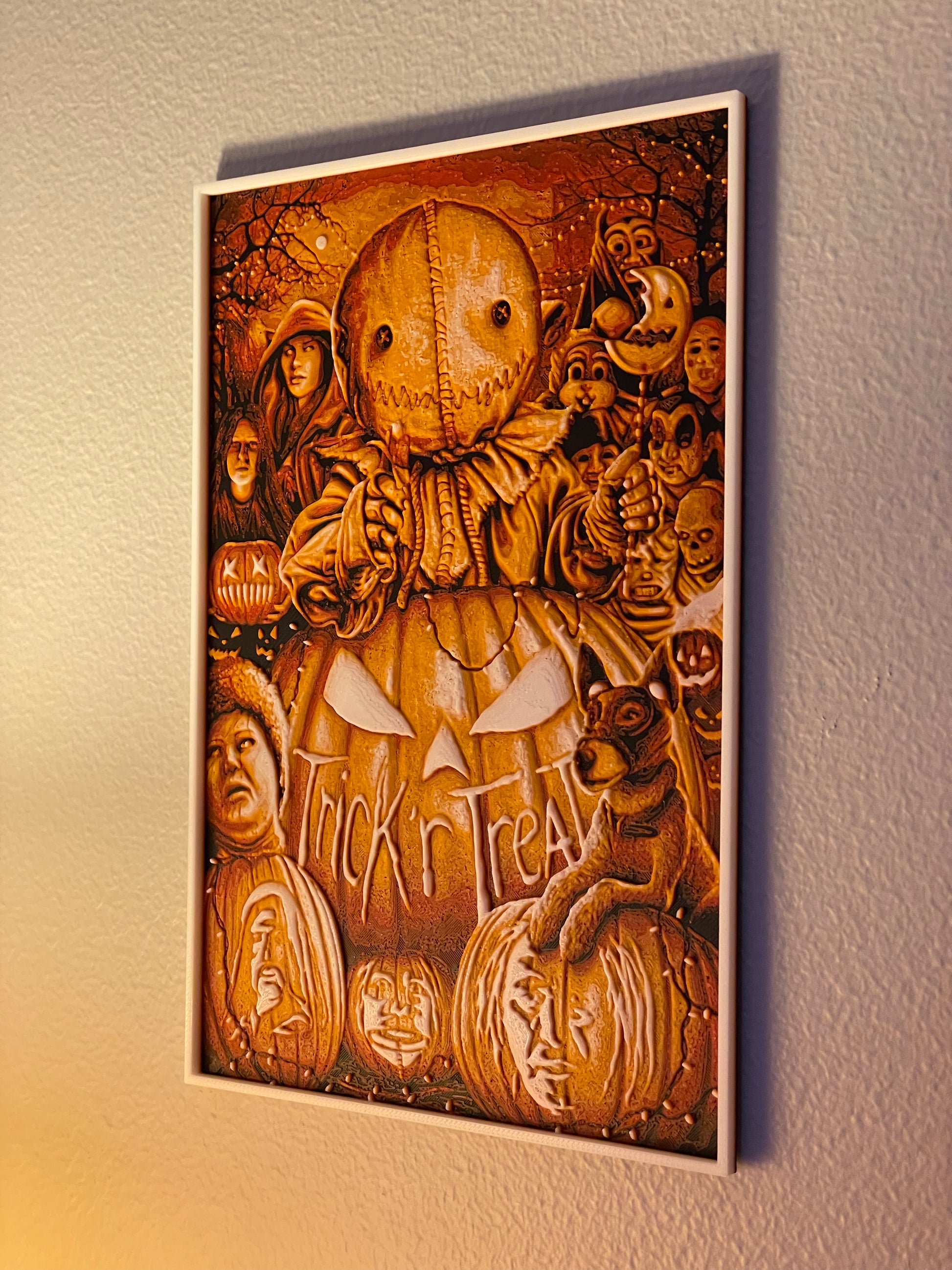 Wooden wall art with Halloween-themed design featuring pumpkins and faces on a plain wall.