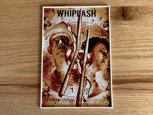 Poster of 'Whiplash' with two faces and drumsticks on a wooden surface